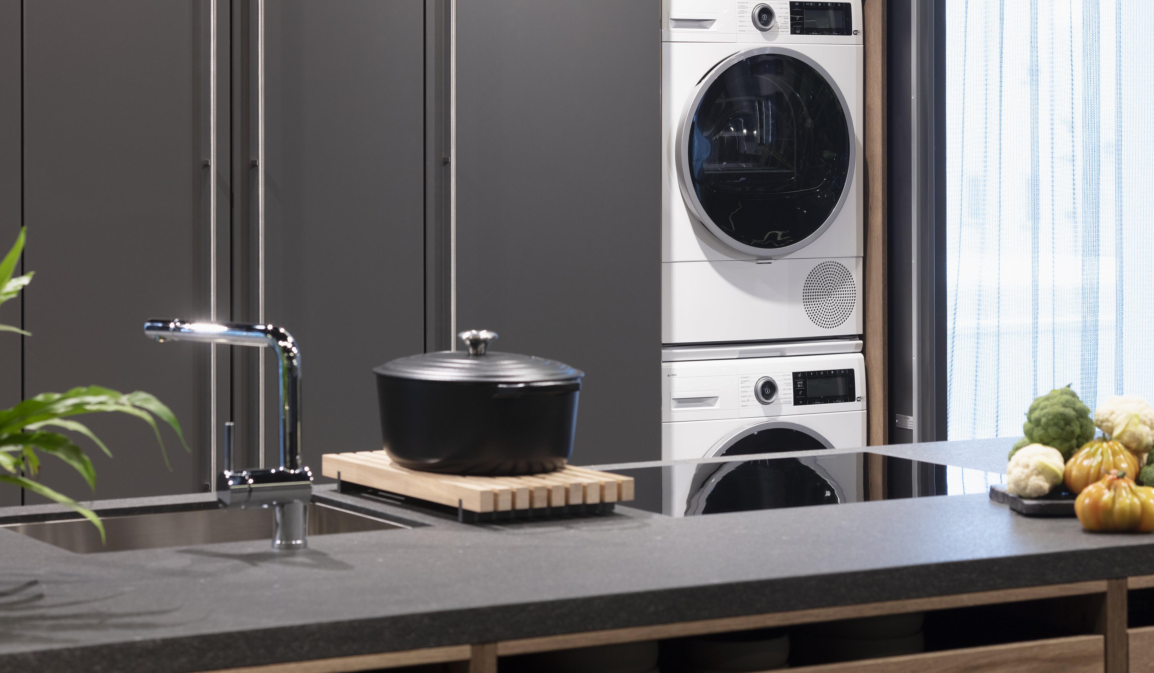Waschmaschine und Trockner in einer LEICHT Küche hinter Pocketdoors